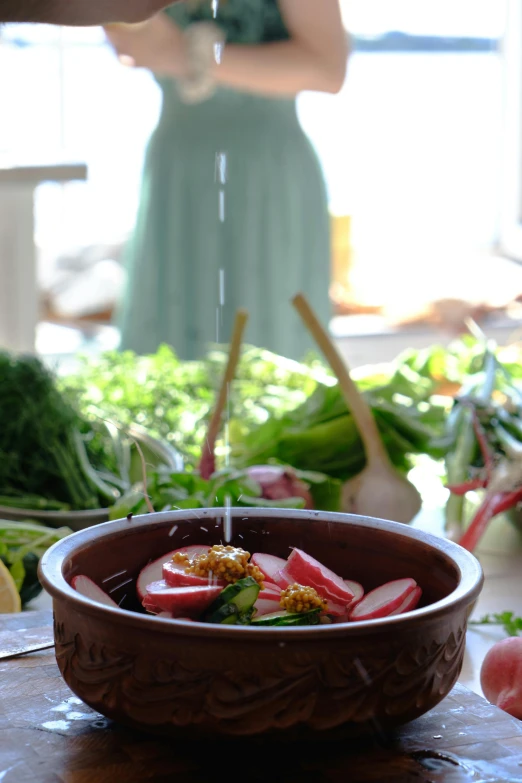 a woman standing next to food on top of a table