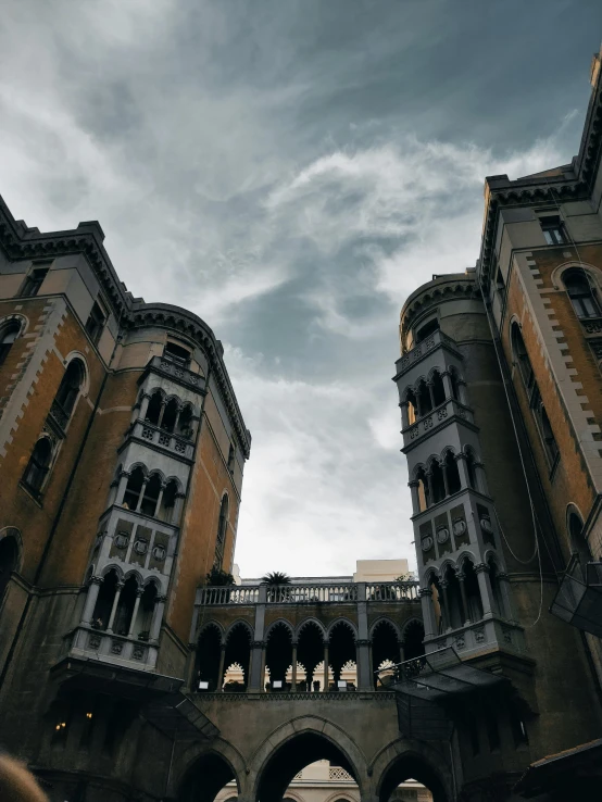 two buildings with arches and arches against a dark sky