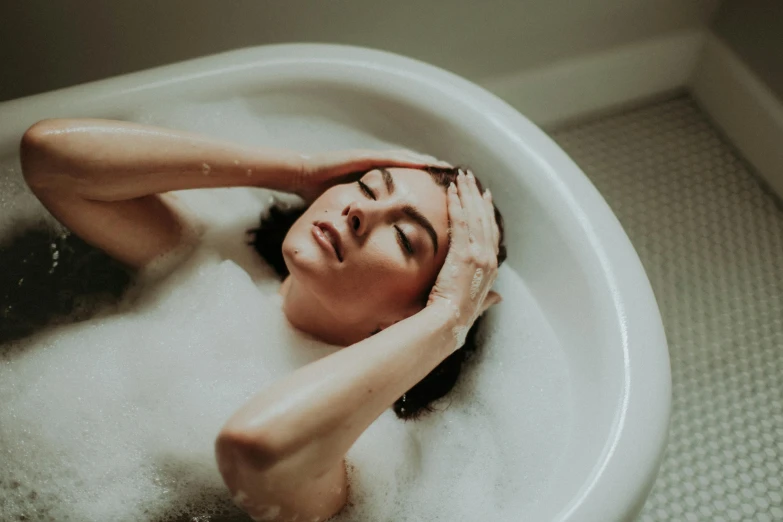 a woman is sitting in the bathtub and enjoying herself