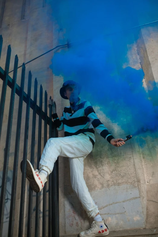 a boy is skateboarding down a wall covered in blue powder