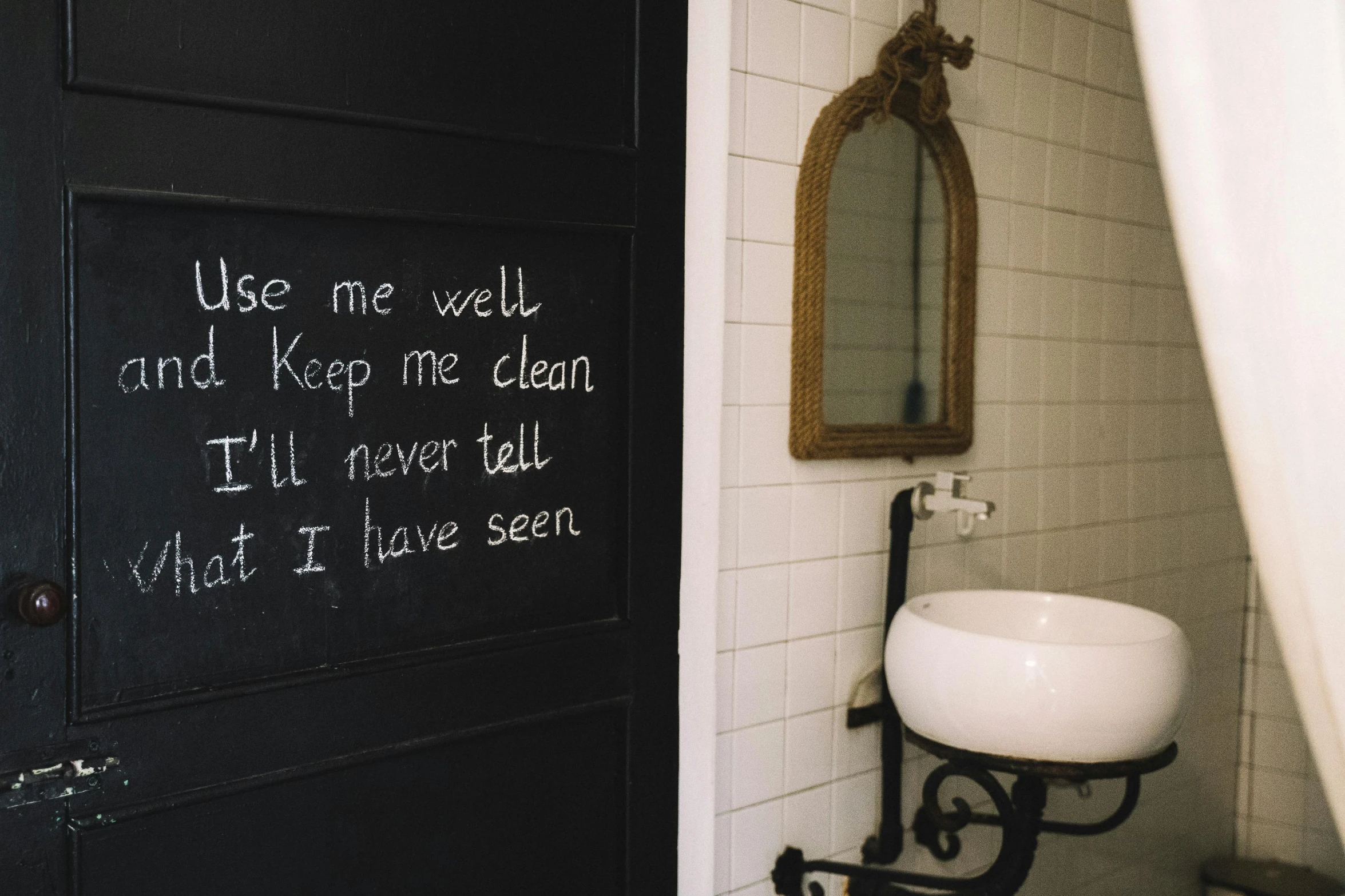 a sink in a bathroom next to a black door