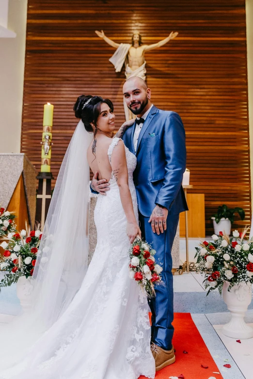 a bride and groom in a church, dressed in blue and wearing white