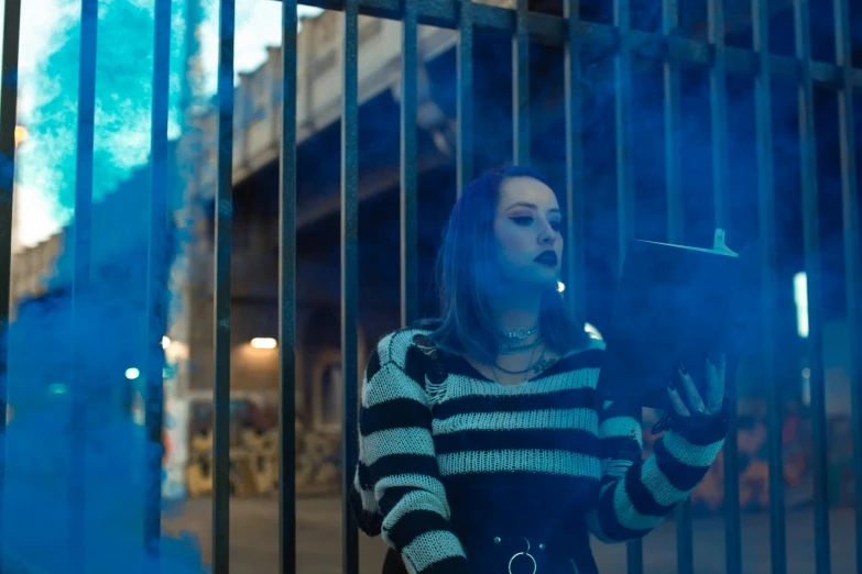a woman smoking a cigarette in a blue smoke bomb