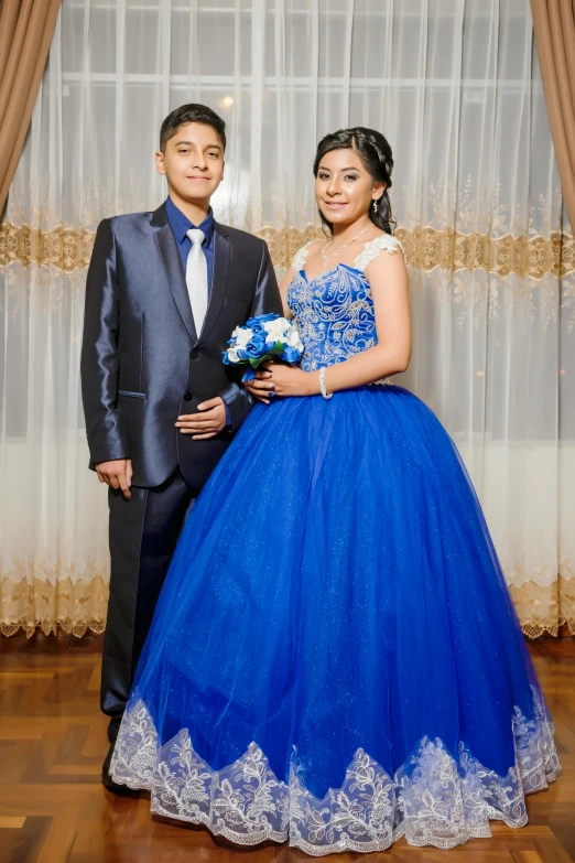 two people pose for a picture on a wooden floor