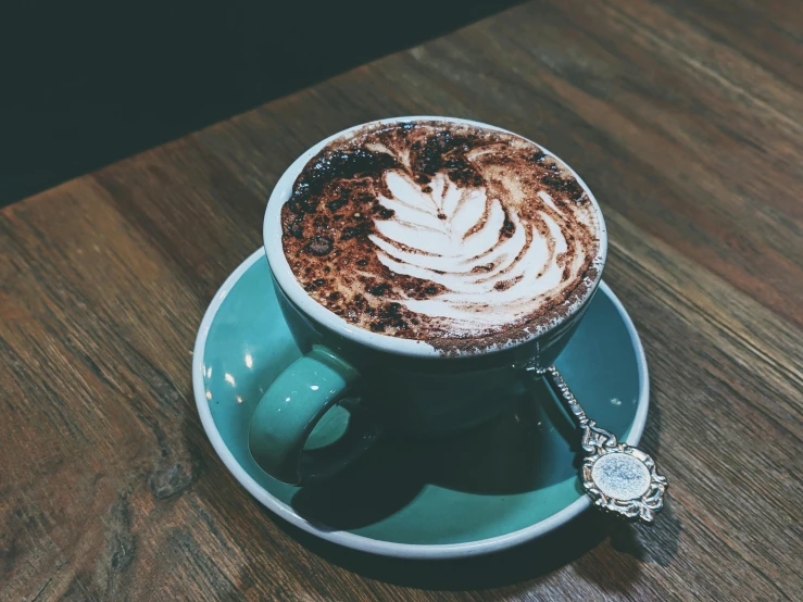 a cappuccino on a saucer next to a watch