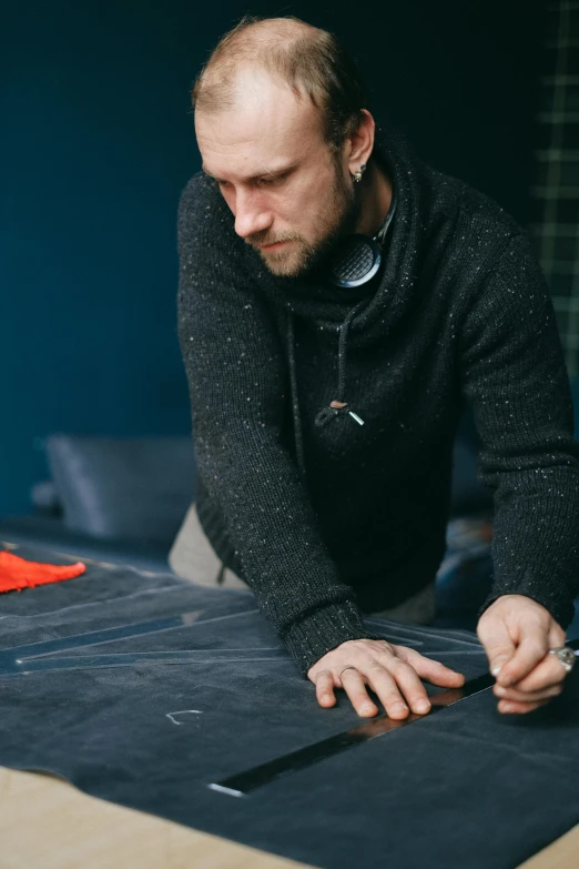 a bearded man making artwork in a studio