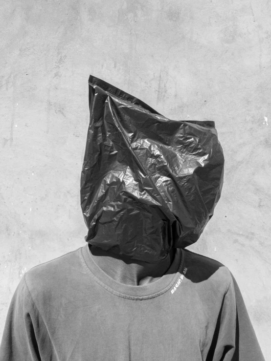 black and white pograph of someone wearing a plastic bag over their head