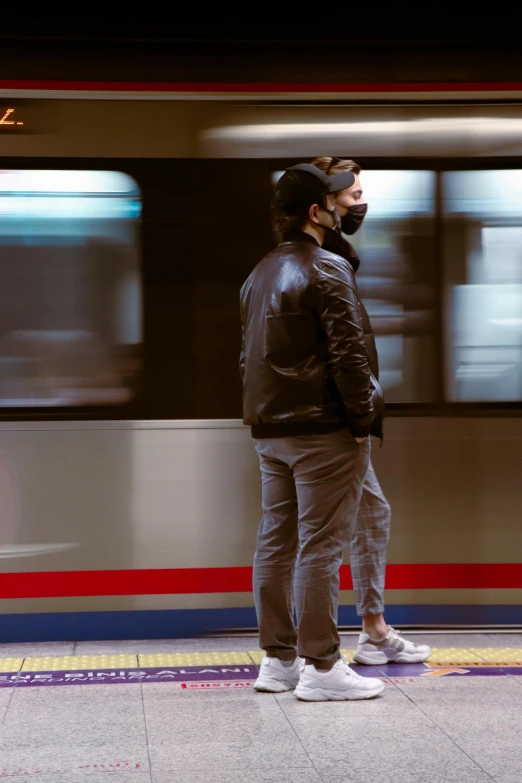 a man stands waiting with his hat on as he waits