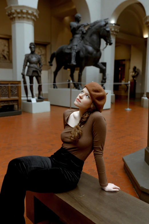 a woman sitting on the bench near a statue