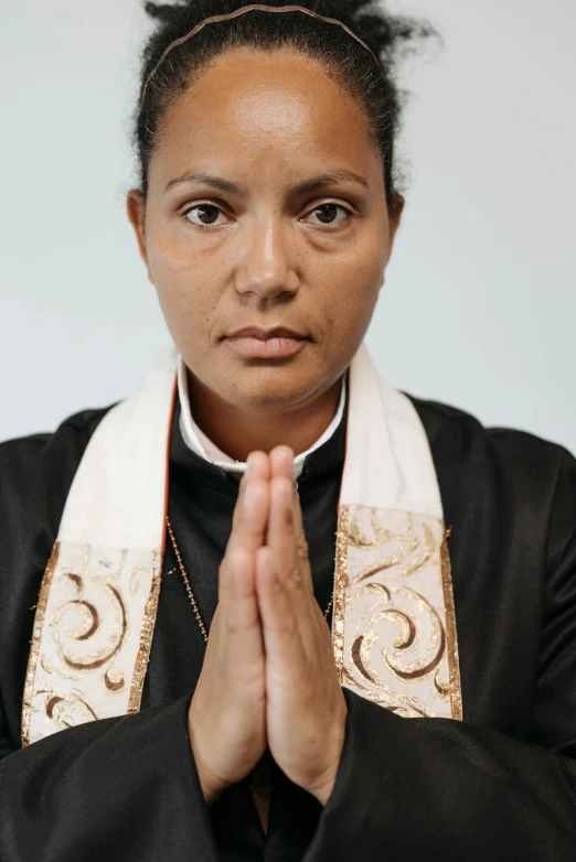 an african american woman has her hands folded in prayer