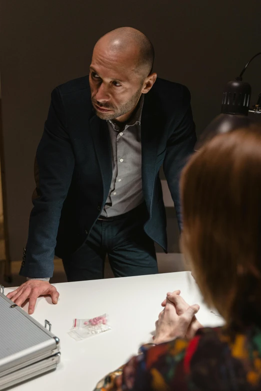 two people are talking to each other at a table