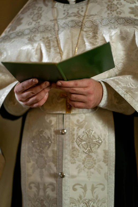 the priests hands of a priest reading a book