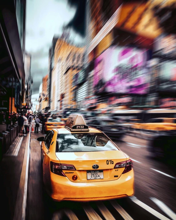 a yellow taxi cab driving down a busy city street