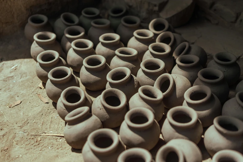 many clay pots that are sitting on the ground