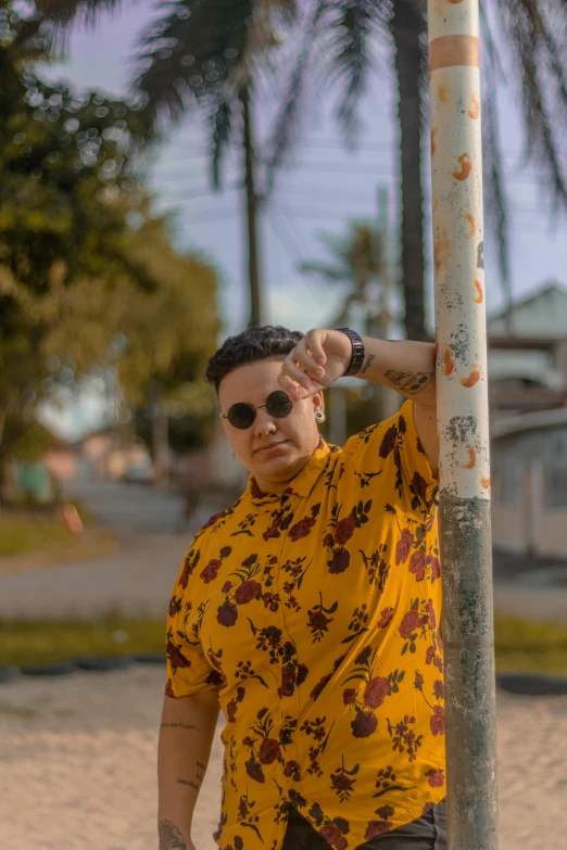 a young man is standing next to a pole