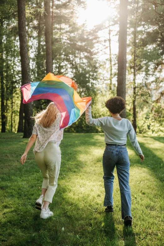 a woman and boy are in the grass flying a kite