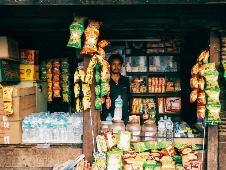 the man stands in front of his store