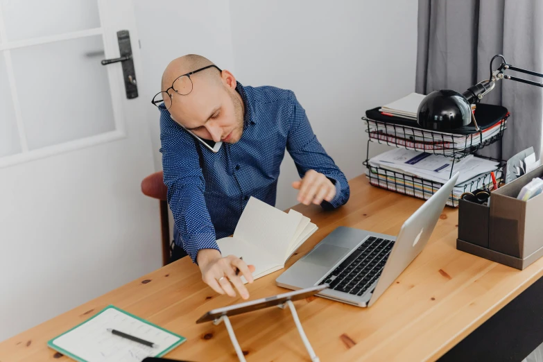 a man with an over head laptop working on his desk