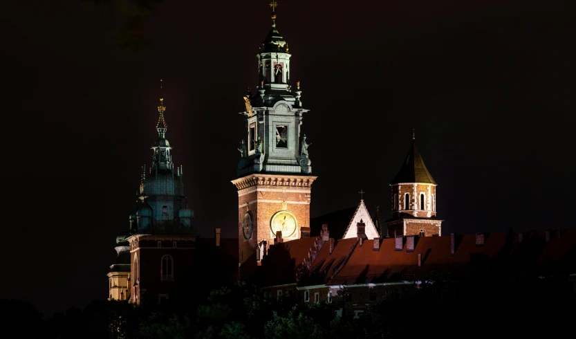 an illuminated tower with two spires rises into the night sky