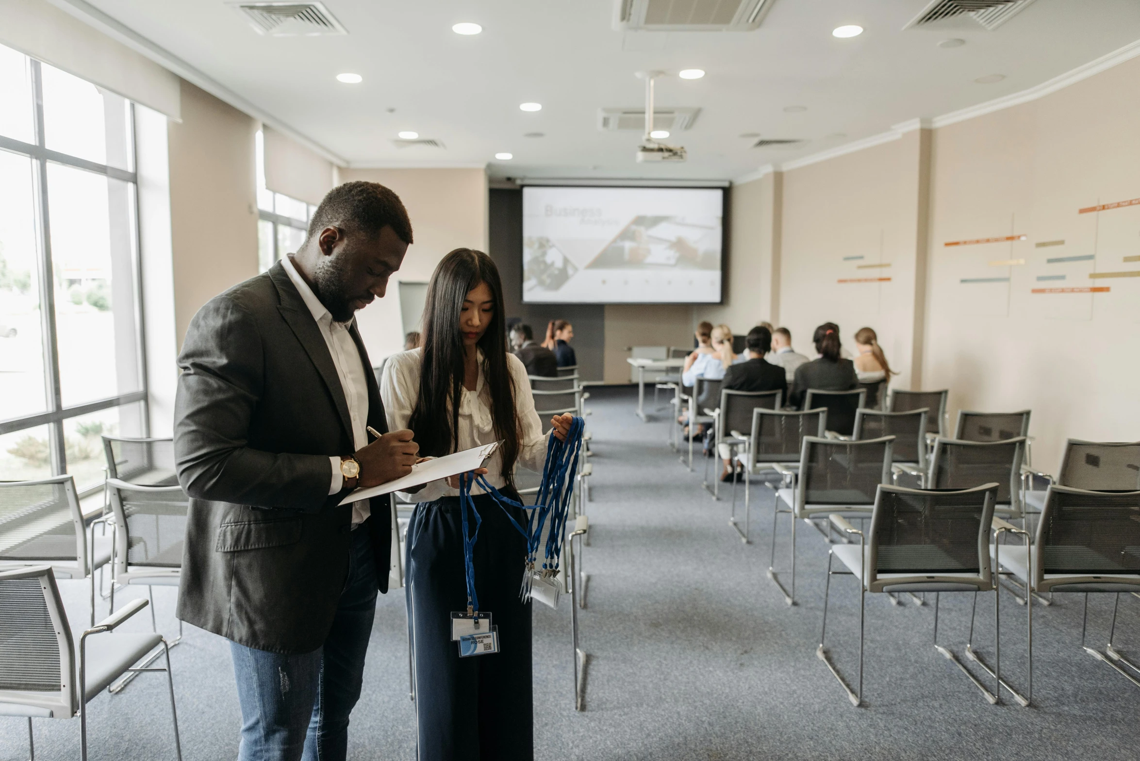 a man is holding soing up near a woman while standing in front of a lecture room