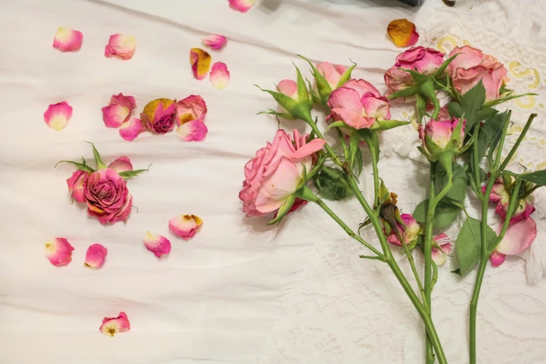 bouquet of roses laying on white and yellow linens