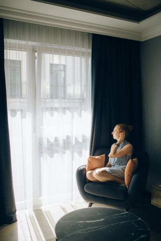 woman in lounge chair next to the window