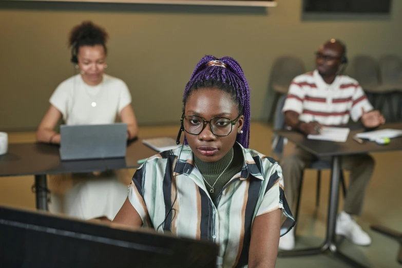 two girls sitting in front of a black computer screen