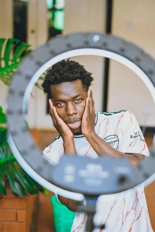 a man with his hand in his face as seen through a circular mirror