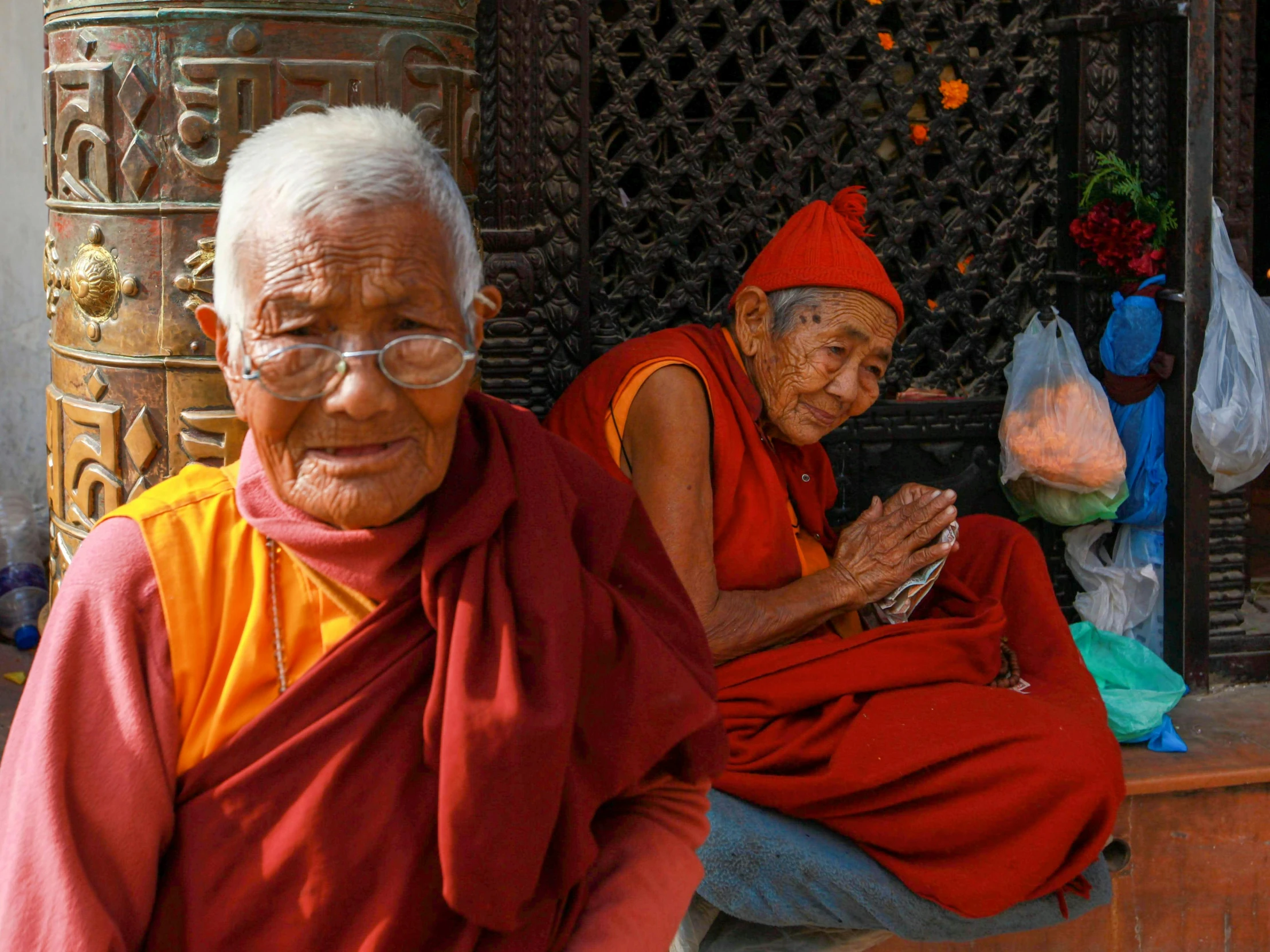 two monks are sitting on the side of a building