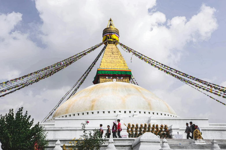 a large long white and gold structure with a lot of people walking up it