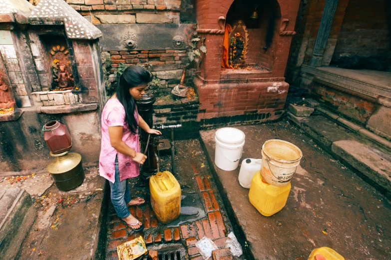 a woman is standing with a shovel by several containers