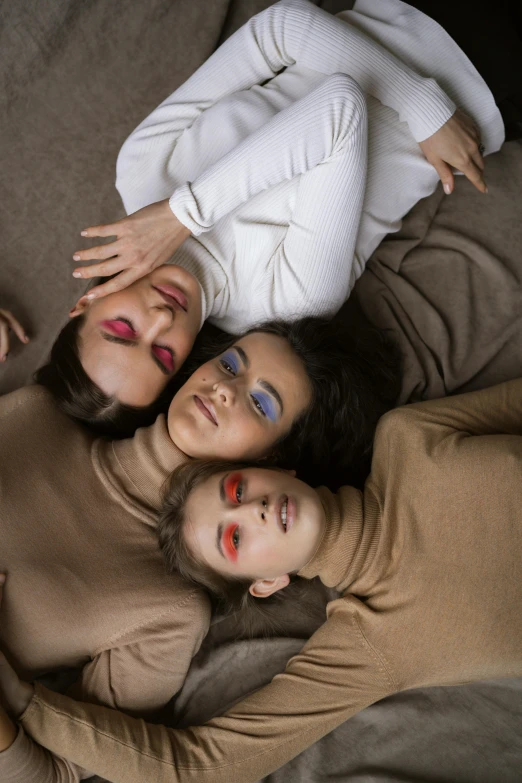 three women and one child laying on the floor together