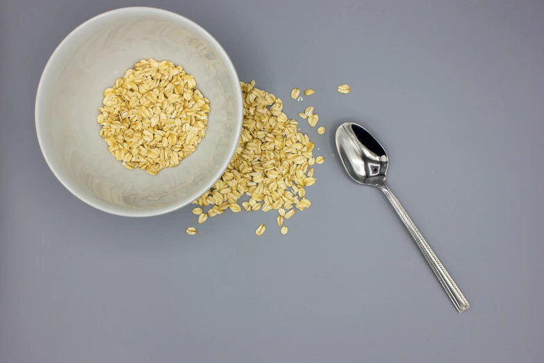 a bowl filled with cereal next to a spoon