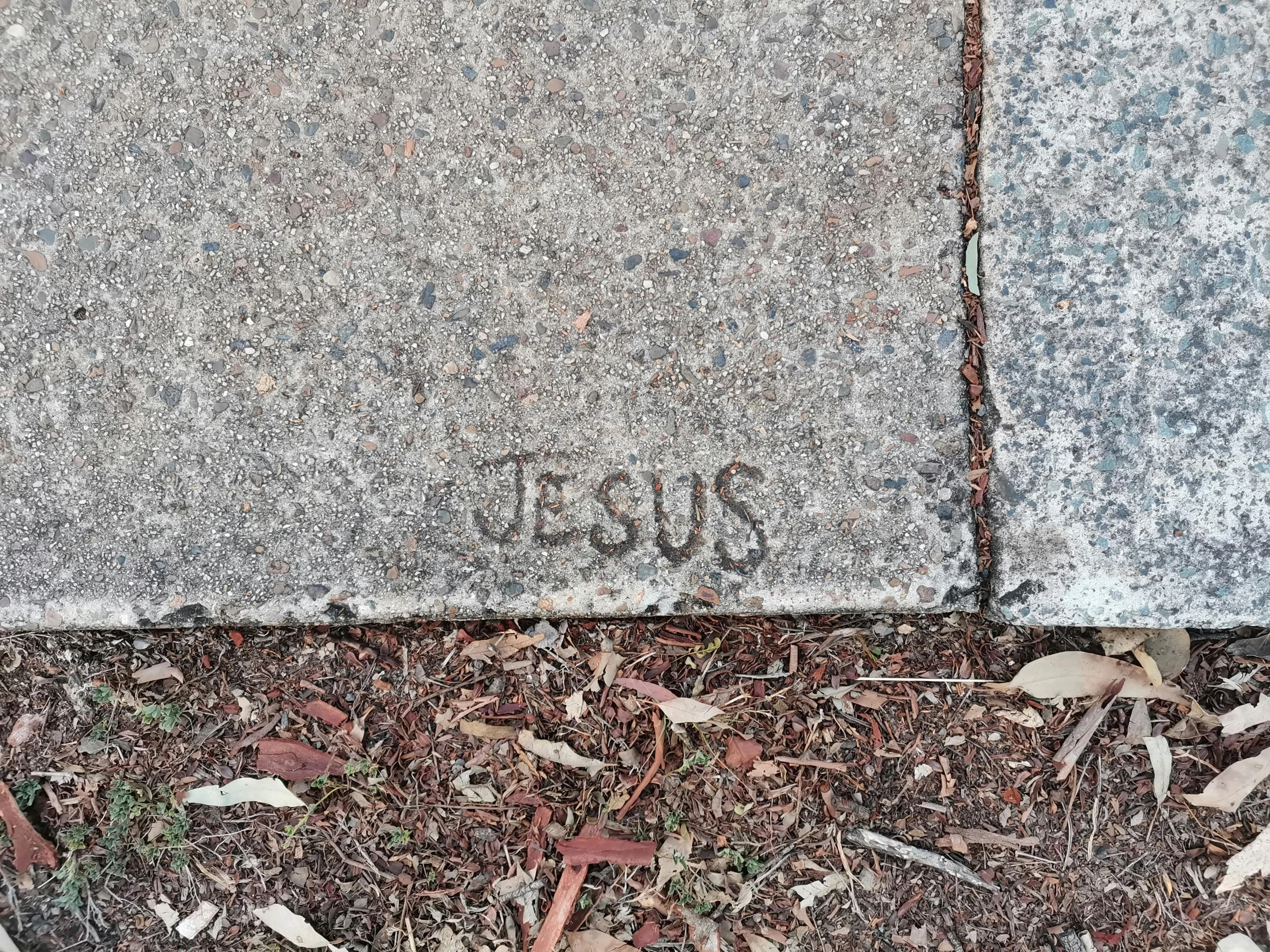 a sidewalk with the number 100 written in a cement wall