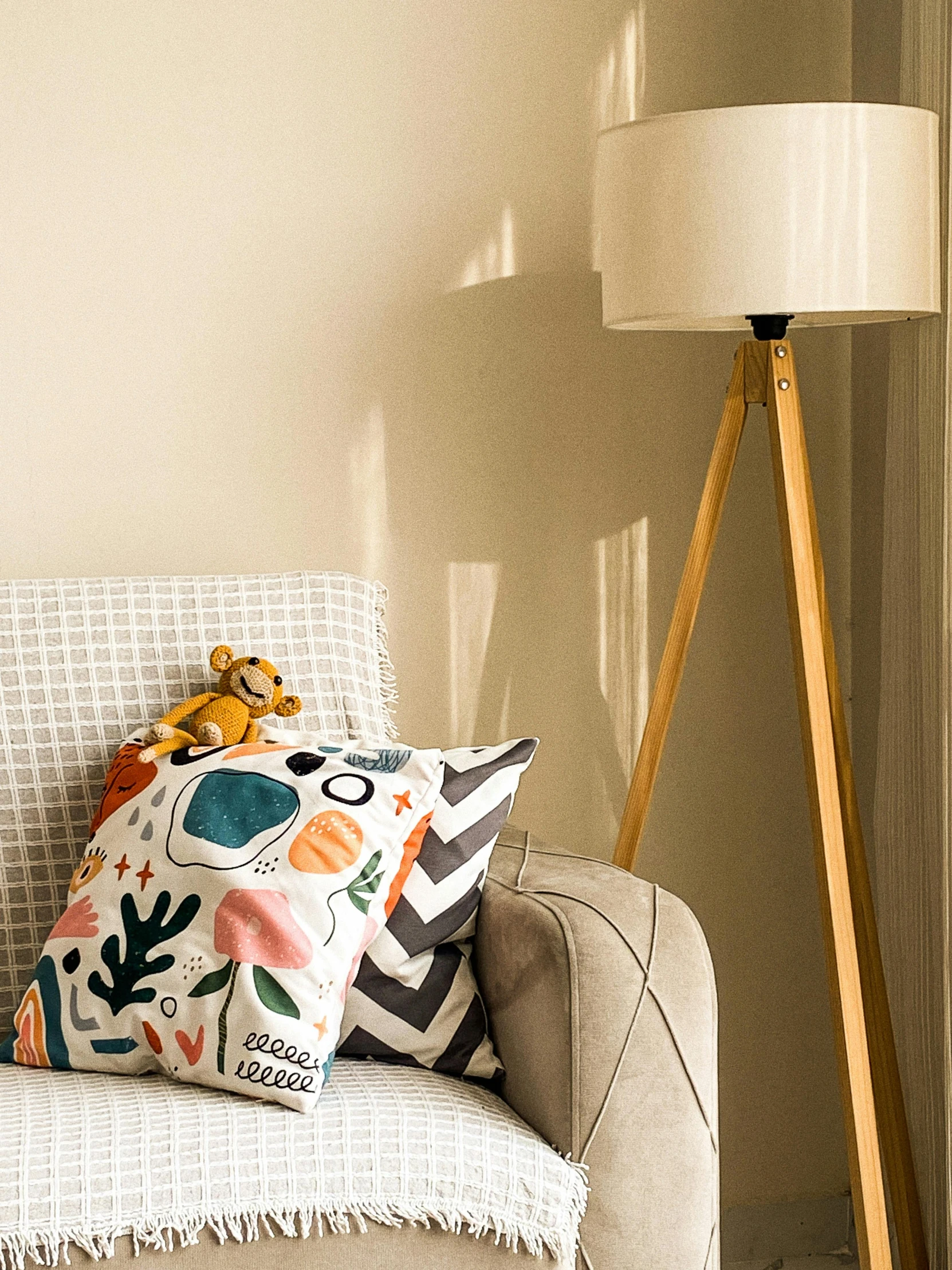 a couch with two pillows on it next to a light filled window