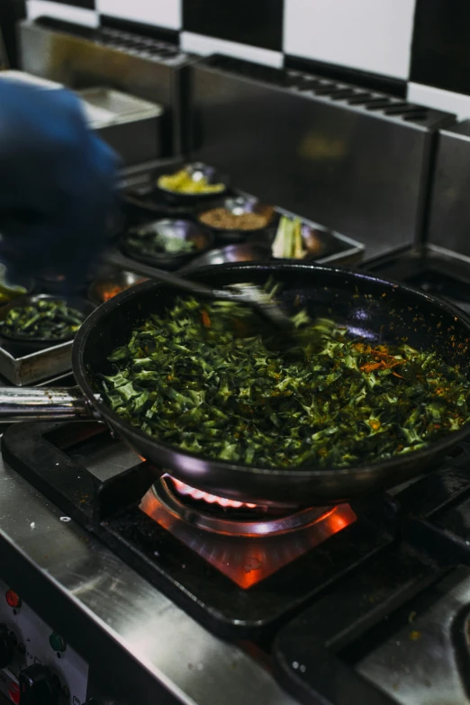a wok filled with food sits on a gas burner