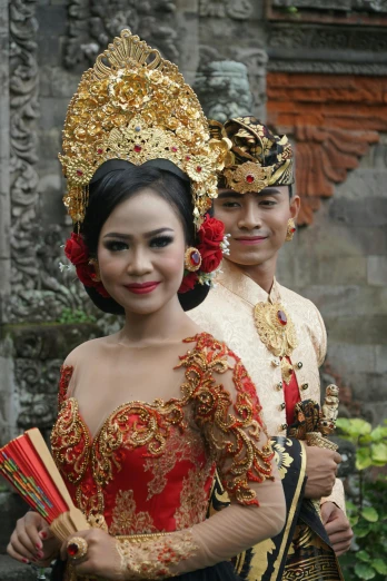a young couple dressed up in traditional indonesian garb