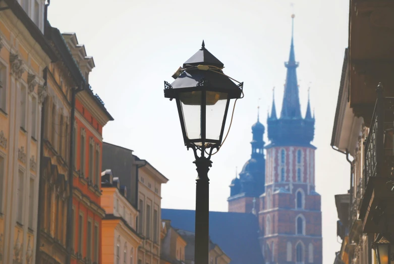 a street lamp near buildings with an old building in the background