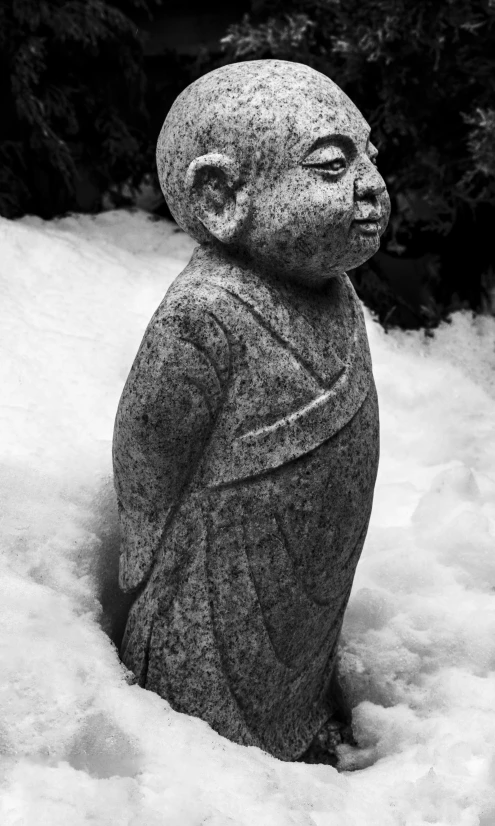 a statue of buddha is in the snow