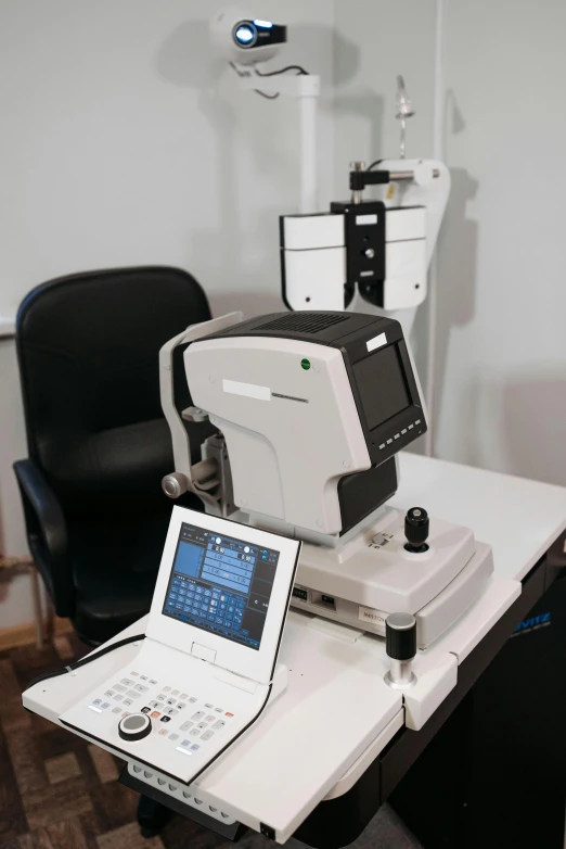 two laptops that are next to a microscope on a table