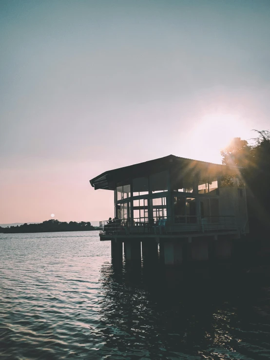 a building floating on top of a lake under a blue sky