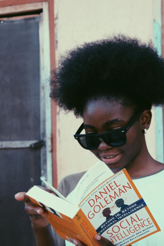 a woman standing outside while reading a book