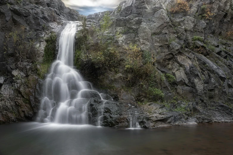 a waterfall in the middle of a green valley