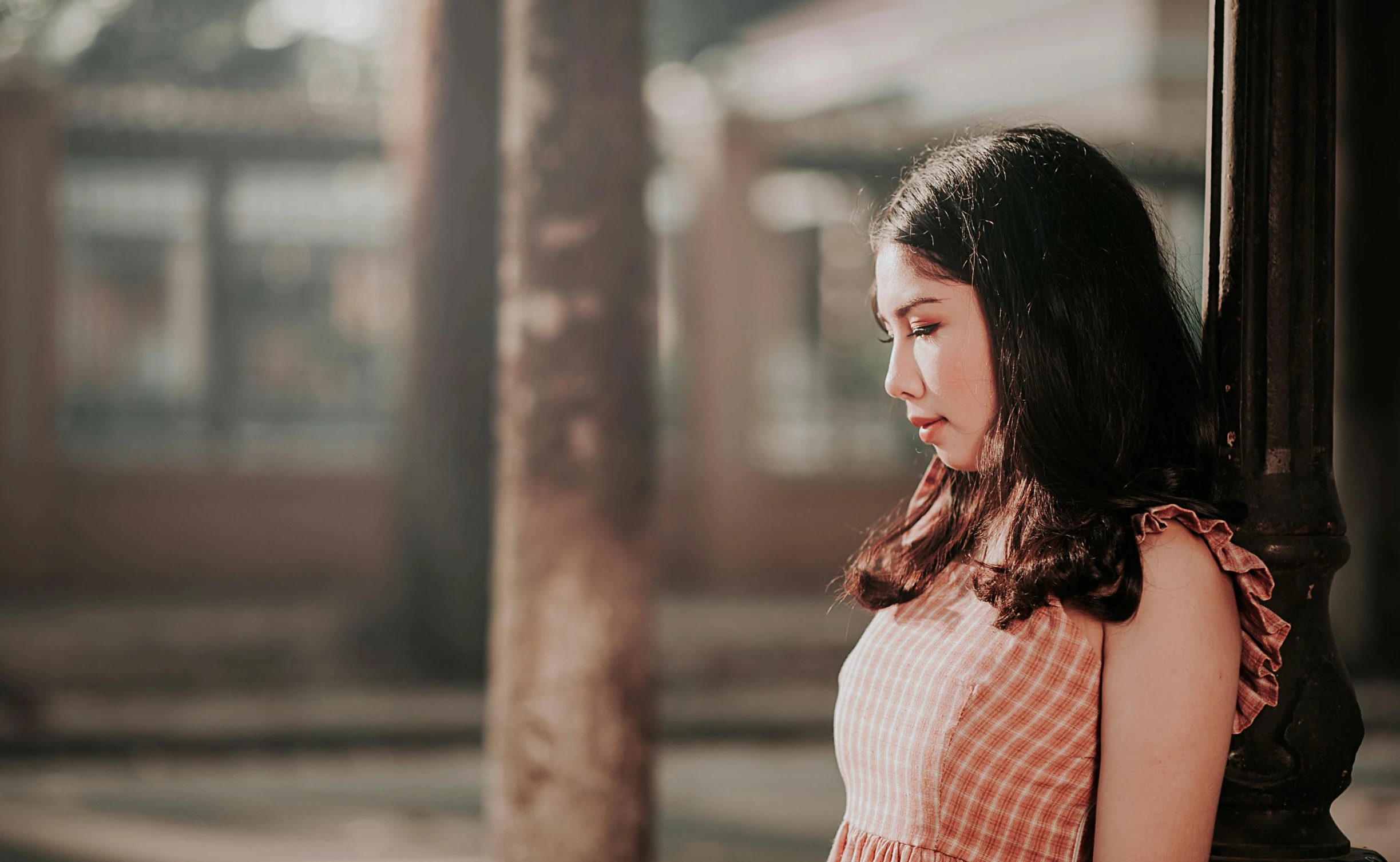 a woman standing by a pole looking at soing