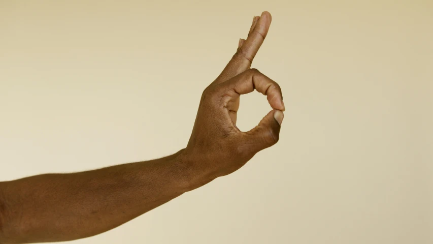 a person holds up their arm to form the letter'd