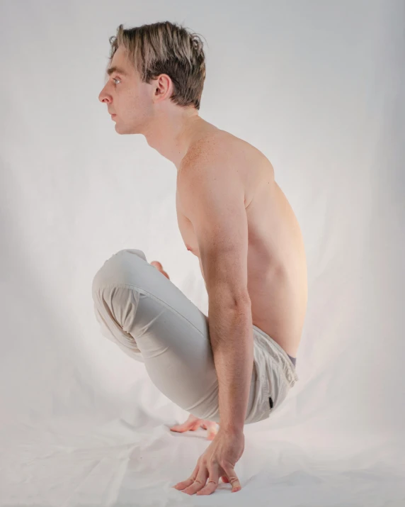 a shirtless young man is posed while bending down