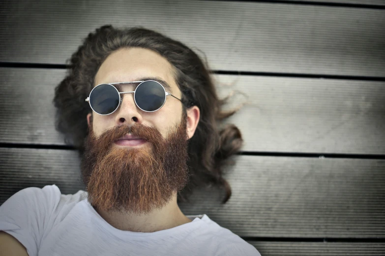 man with beard and sunglasses looking up to camera