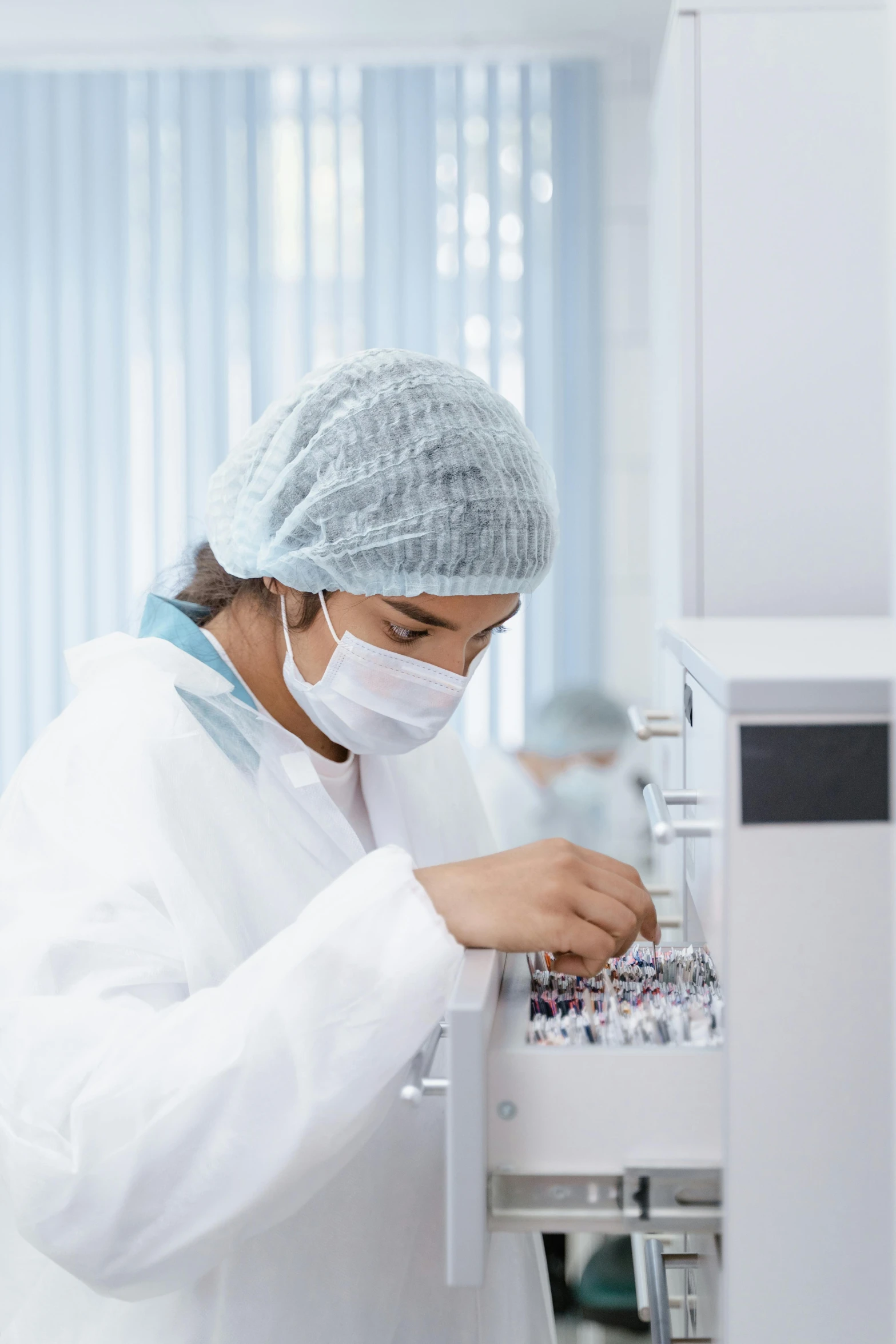 a person with white surgical gear and gloves working on soing