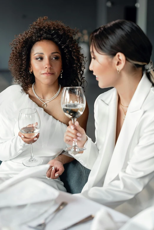 the woman sits with two wine glasses on her lap