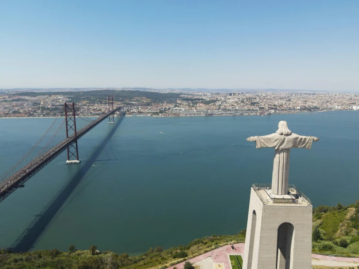 the view of a bridge that spans over the water and has an statue on top